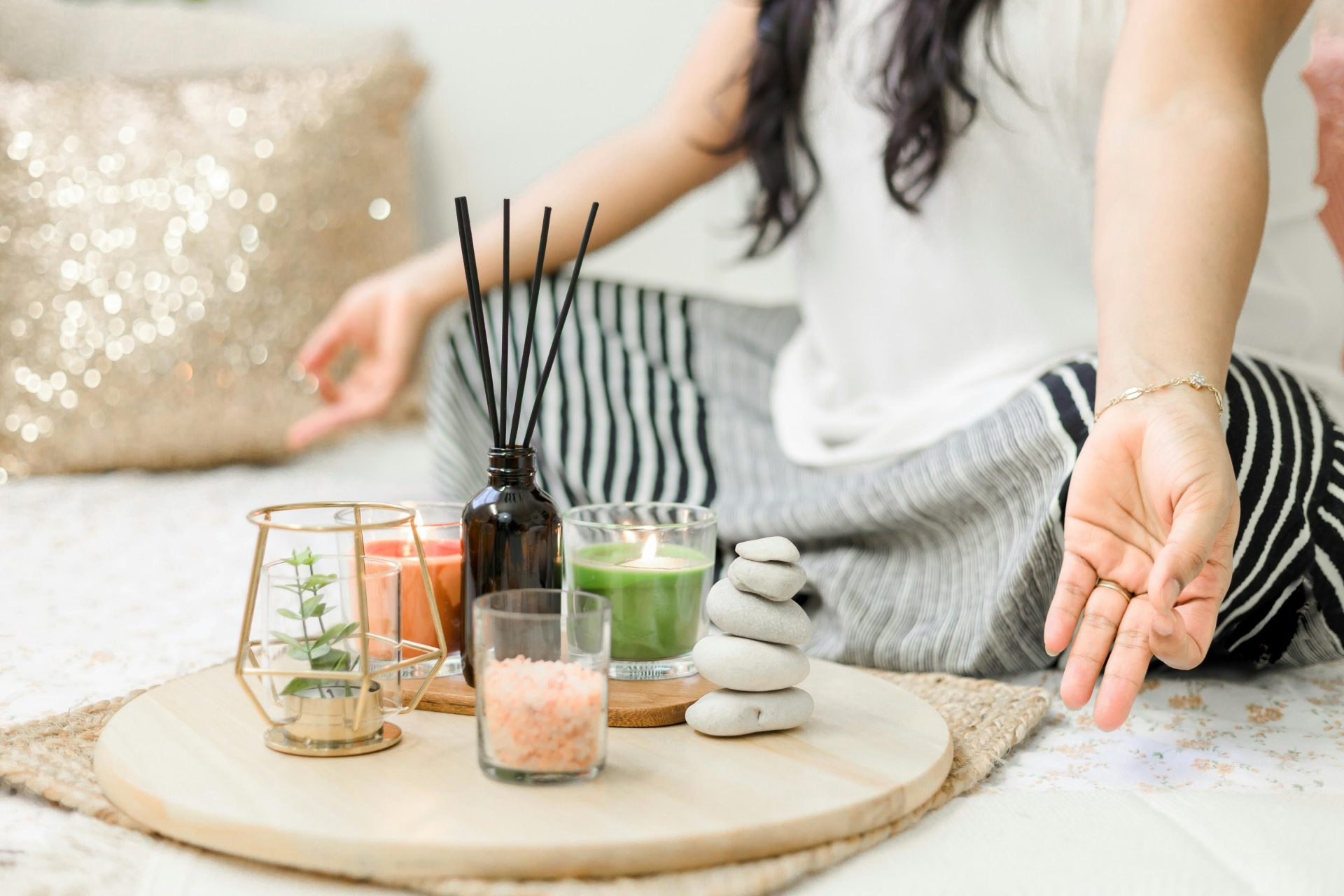 Woman practicing meditation in front of aromatic candles